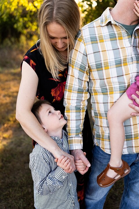 Family standing together at Towne Park during a golden afternoon.
Kids smiling and posing on a gravel path at Towne Park.
Parents laughing while holding their children during the session.
Children running through a sunny field at Towne Park.
Family cuddled together on a grassy patch beneath tall trees.