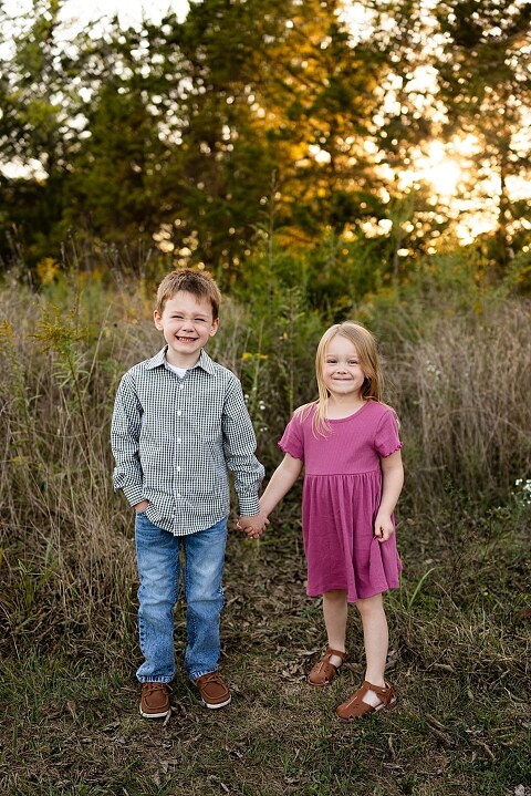 Family standing together at Towne Park during a golden afternoon.
Kids smiling and posing on a gravel path at Towne Park.
Parents laughing while holding their children during the session.
Children running through a sunny field at Towne Park.
Family cuddled together on a grassy patch beneath tall trees.
