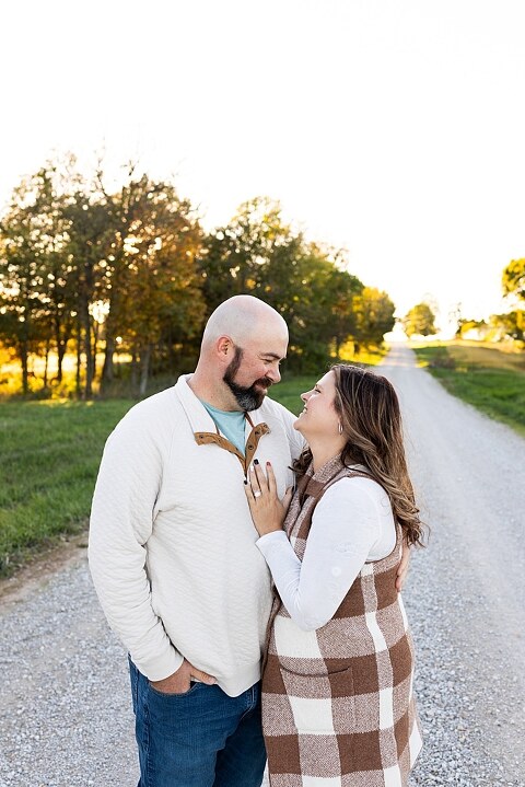 Family standing together on a gravel road in High Hill Missouri.
Kids smiling and walking down a sunny gravel path.
Mom hugging her two kids during their gravel road session.
Children running through a field beside a country road.
Family laughing together in warm evening light.