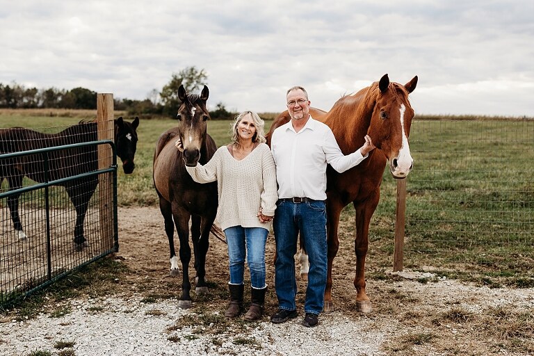 Couple standing together on their new country property during golden hour.
Tina and Jimmy laughing together beside a tall tree line.
Couple posing with one of their farm animals in soft evening light.
Tina and Jimmy walking hand in hand across their open field.
Close-up of the couple smiling with their animals nearby.