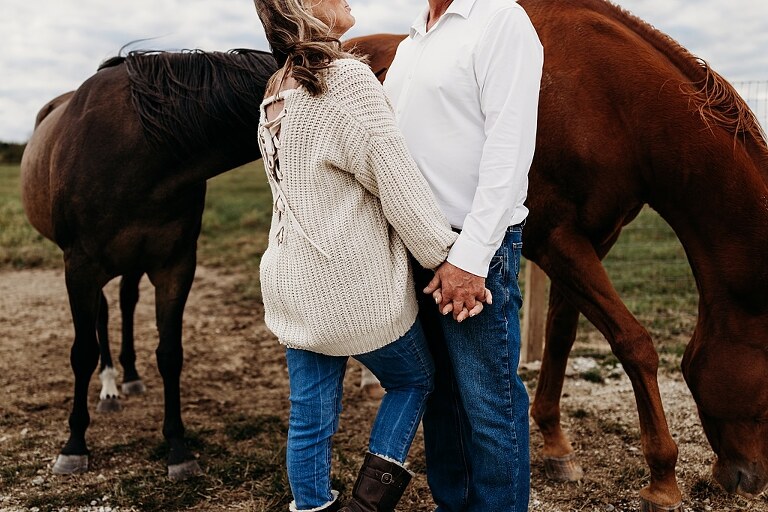 Couple standing together on their new country property during golden hour.
Tina and Jimmy laughing together beside a tall tree line.
Couple posing with one of their farm animals in soft evening light.
Tina and Jimmy walking hand in hand across their open field.
Close-up of the couple smiling with their animals nearby.
