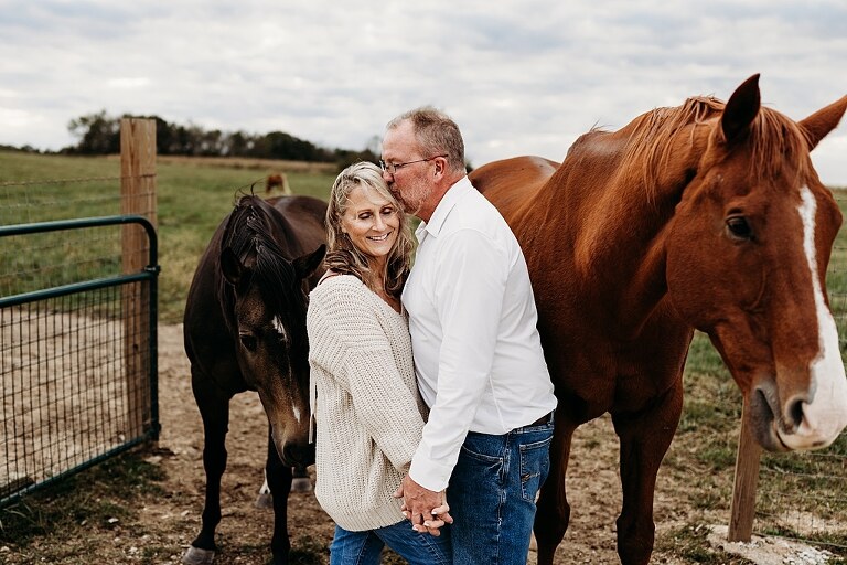 Couple standing together on their new country property during golden hour.
Tina and Jimmy laughing together beside a tall tree line.
Couple posing with one of their farm animals in soft evening light.
Tina and Jimmy walking hand in hand across their open field.
Close-up of the couple smiling with their animals nearby.
