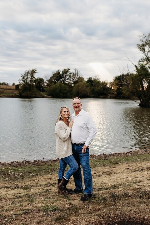 Couple standing together on their new country property during golden hour.
Tina and Jimmy laughing together beside a tall tree line.
Couple posing with one of their farm animals in soft evening light.
Tina and Jimmy walking hand in hand across their open field.
Close-up of the couple smiling with their animals nearby.