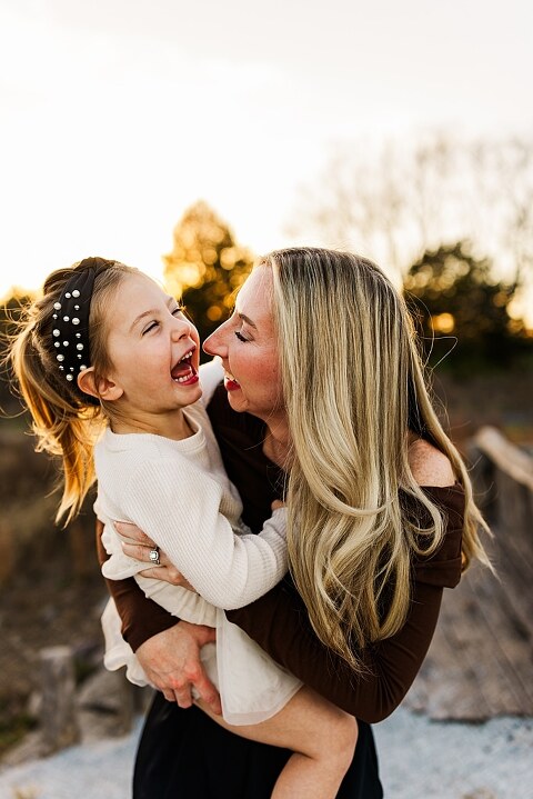 Family standing together at Towne Park in Foristell Missouri during golden hour.
Parents holding their children while laughing in an open field.
Family walking along a tree-lined path at Towne Park.
Kids smiling while standing between their parents during the session.
Close-up of Rob and Taylor hugging with soft light behind them.
