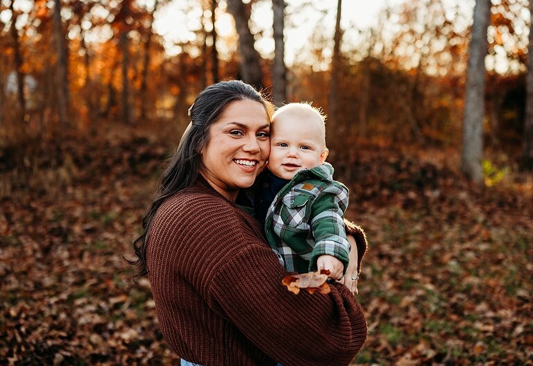 Family holding their baby during a session in High Hill Missouri.
Parents kissing their smiling little boy in warm natural light.
Baby laughing while sitting with his parents on a country path.
Family walking together through a grassy field.
Close-up of baby boy smiling during his milestone session.