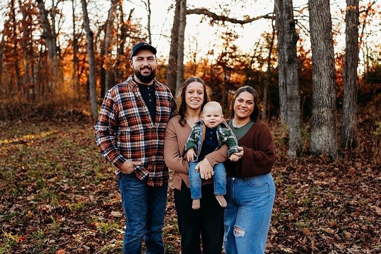 Family holding their baby during a session in High Hill Missouri.
Parents kissing their smiling little boy in warm natural light.
Baby laughing while sitting with his parents on a country path.
Family walking together through a grassy field.
Close-up of baby boy smiling during his milestone session.